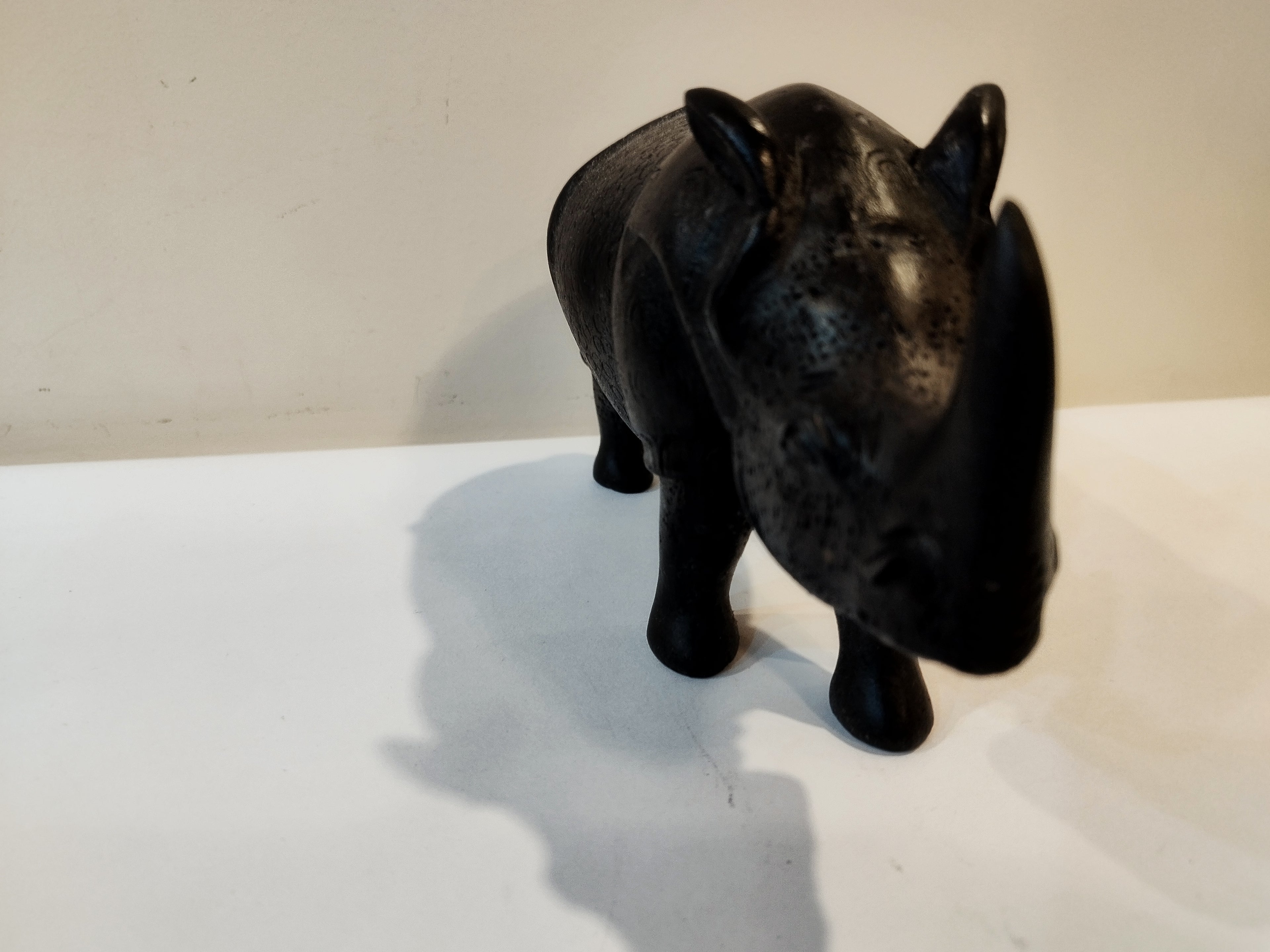 Rhino in black wood, five inches height and nine inch in length. Well known to give strength to a person, family, office.