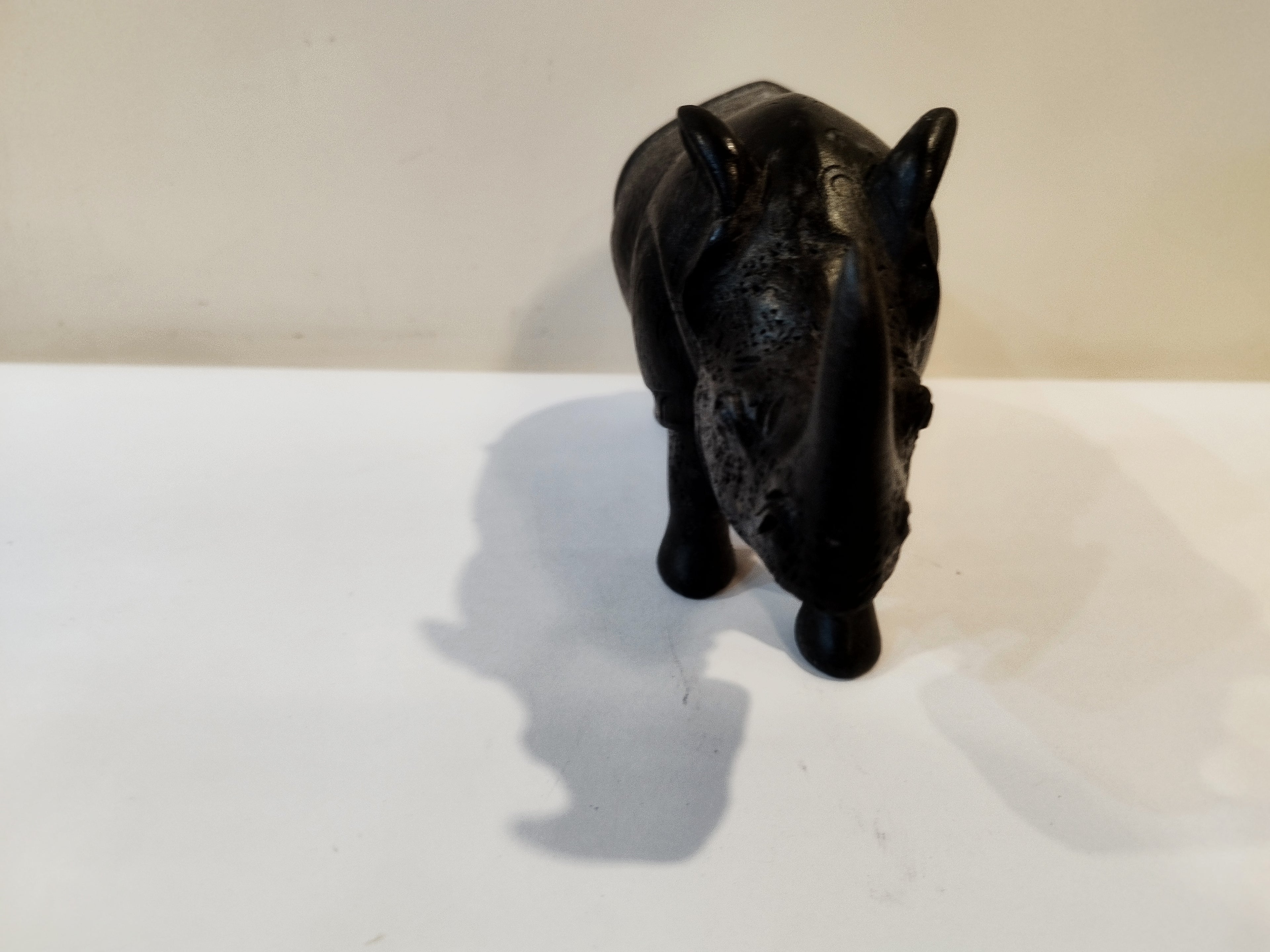 Rhino in black wood, five inches height and nine inch in length. Well known to give strength to a person, family, office.