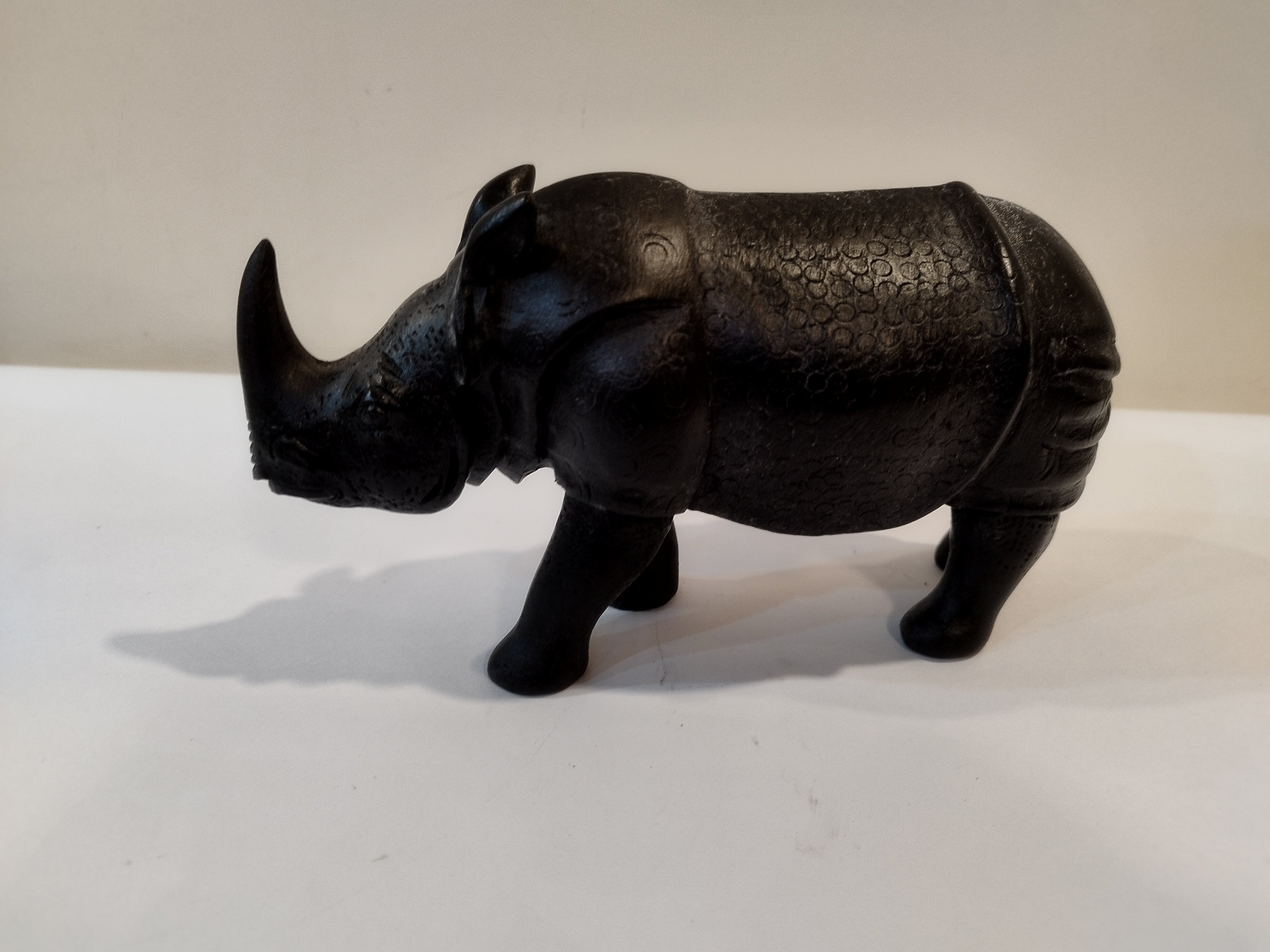 Rhino in black wood, five inches height and nine inch in length. Well known to give strength to a person, family, office.