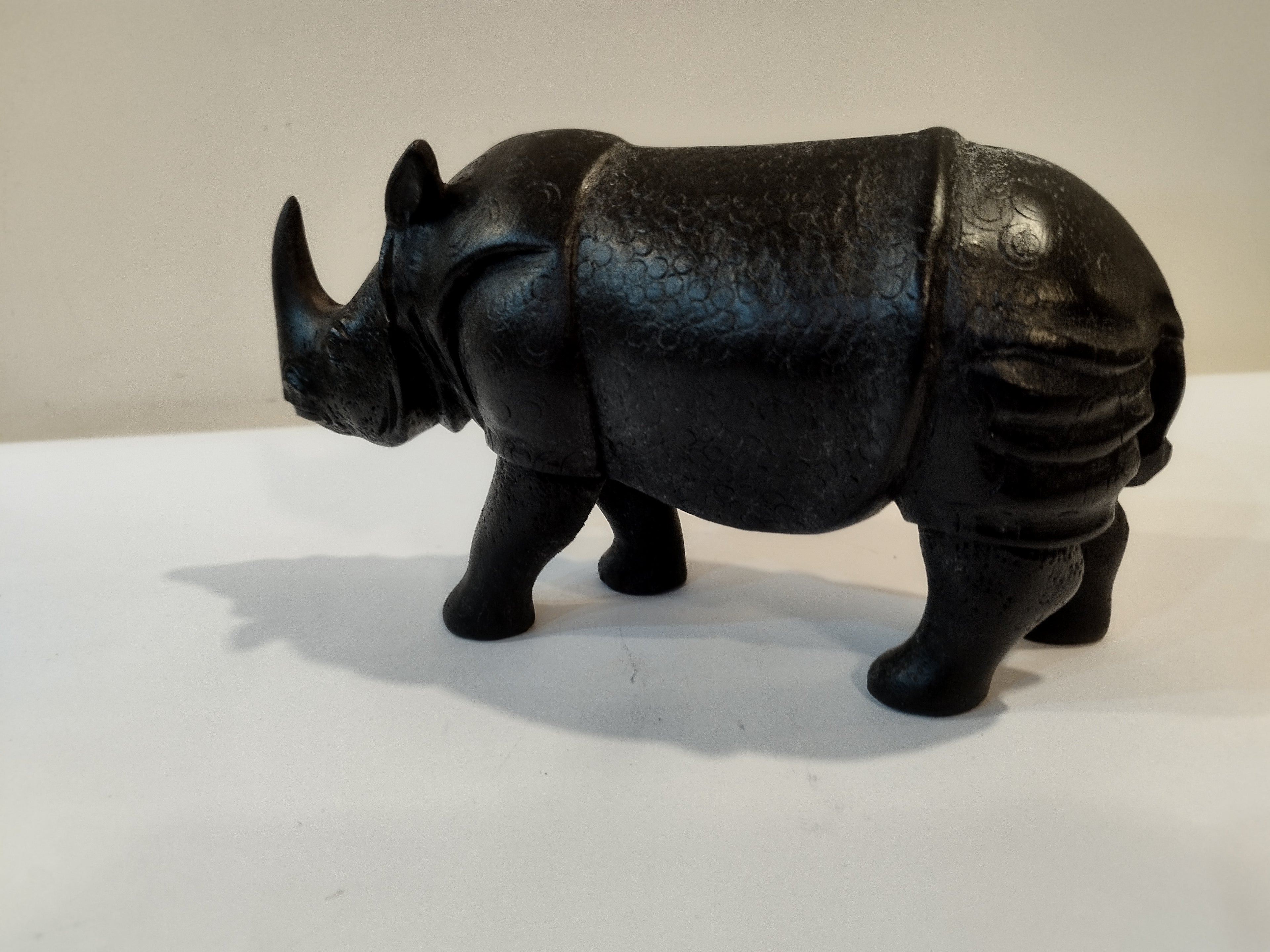 Rhino in black wood, five inches height and nine inch in length. Well known to give strength to a person, family, office.