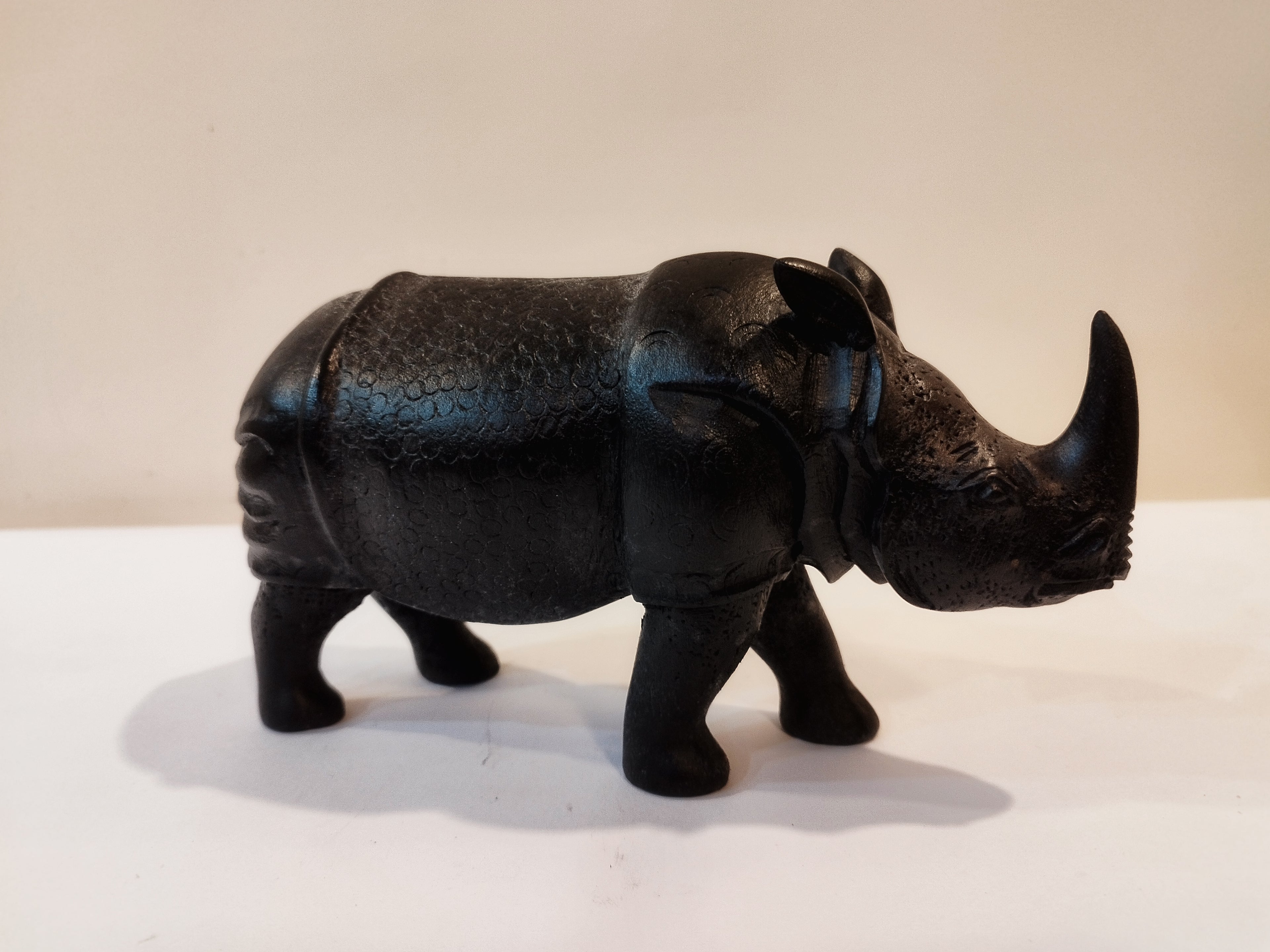 Rhino in black wood, five inches height and nine inch in length. Well known to give strength to a person, family, office.