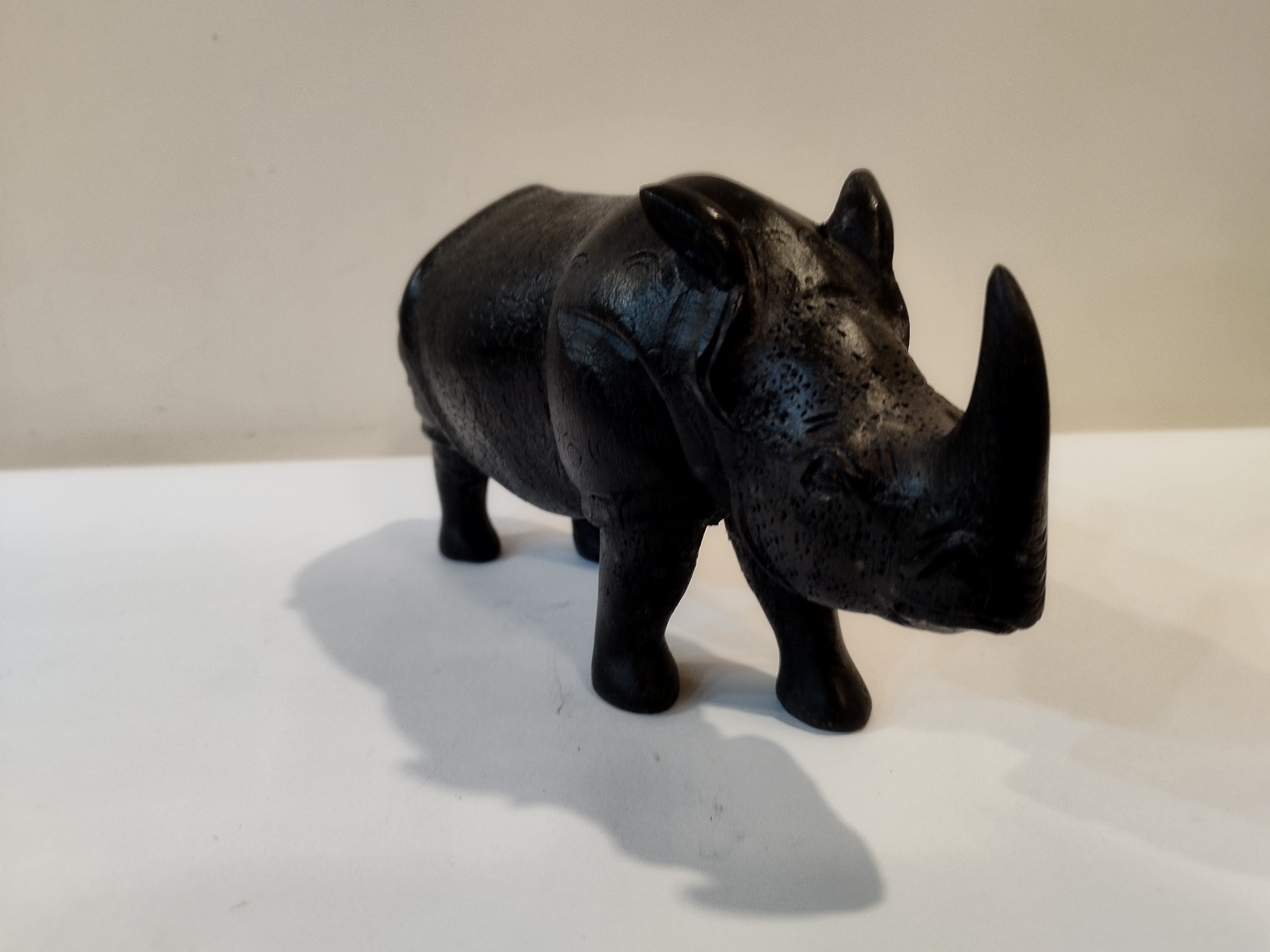 Rhino in black wood, five inches height and nine inch in length. Well known to give strength to a person, family, office.